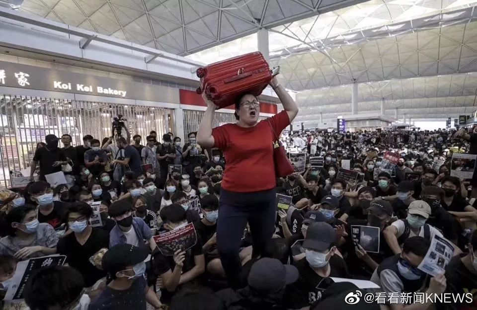 面對(duì)香港機(jī)場(chǎng)滿地示威者 新加坡紅衣女子沖了出去