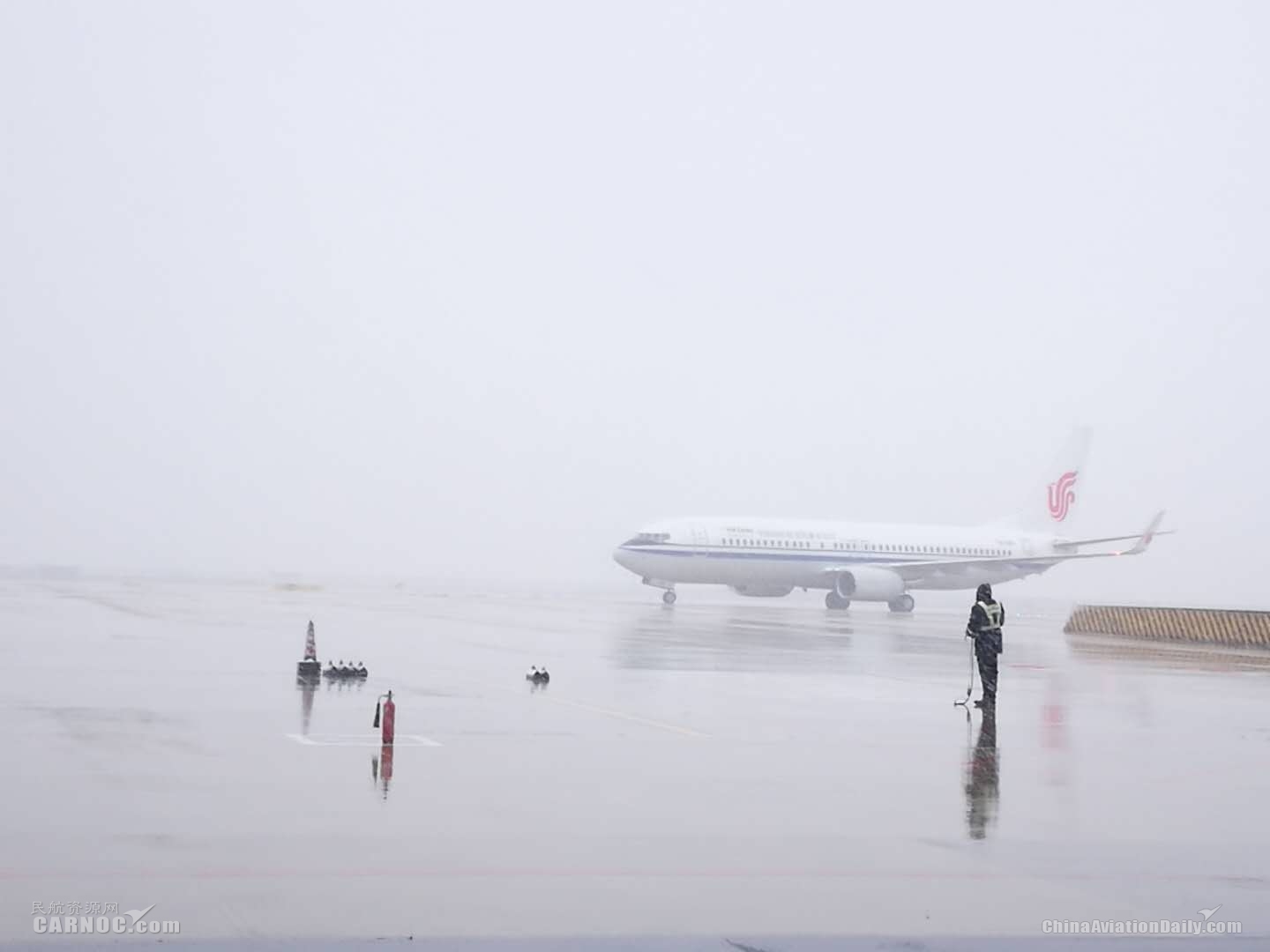 武漢分公司機務(wù)人員引導(dǎo)執(zhí)行CA089航班的飛機入港　攝影：曾波