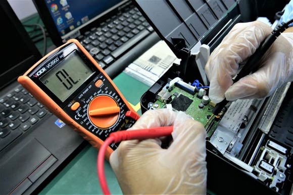 維修技術(shù)人員對佳能打印機進行調(diào)試檢測